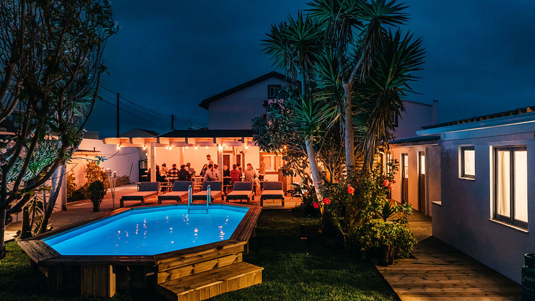 Enjoy the evening light with old and new friends Community in our Pure Surf Camp Peniche by the pool