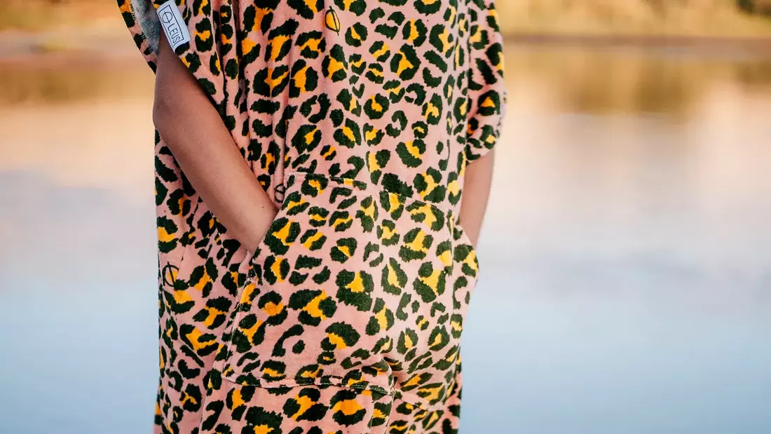 Klassisch einfarbig oder bunter Print: Beim Surf Poncho Design sind keine Grenzen gesetzt surfponcho im leoparden print mit bauchtasche von nah