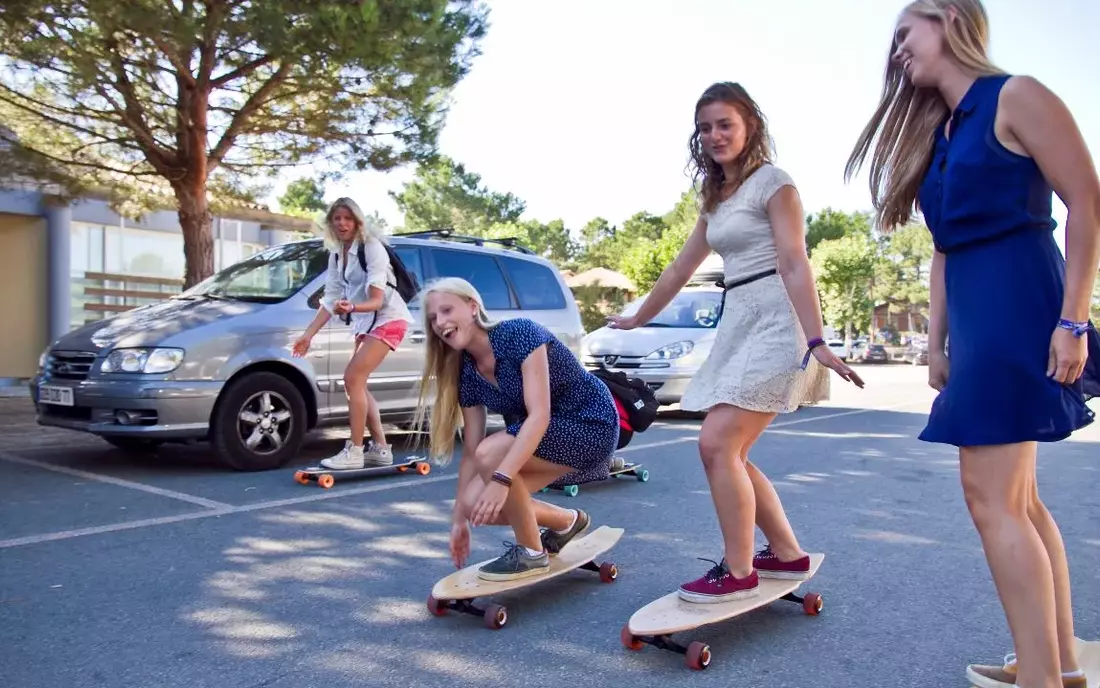 Free rental longboards in the camp girls skating longboard at surf camp zarautz