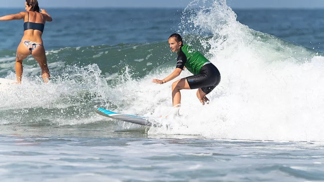 Surferin beim Surfenlernen im Weißwasser