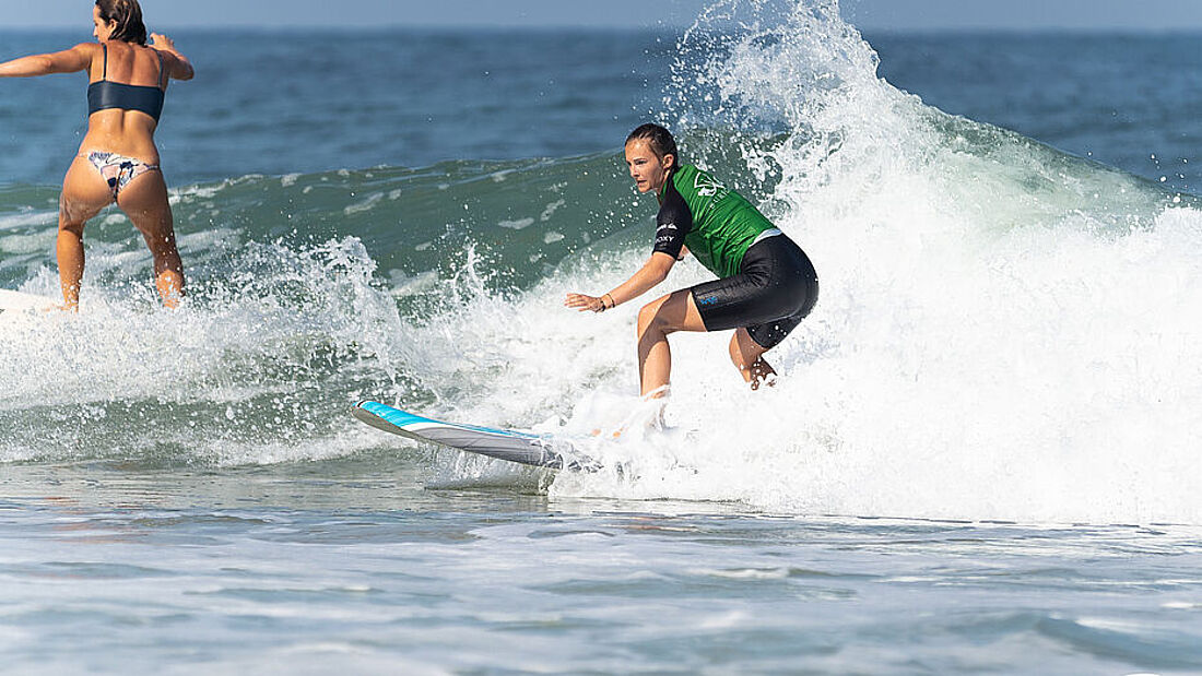 Surferin beim Surfenlernen im Weißwasser