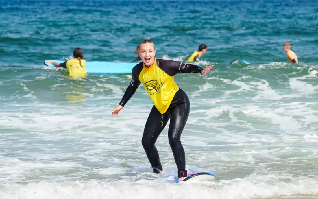 Surferin beim Surfen lernen im Surfkurs