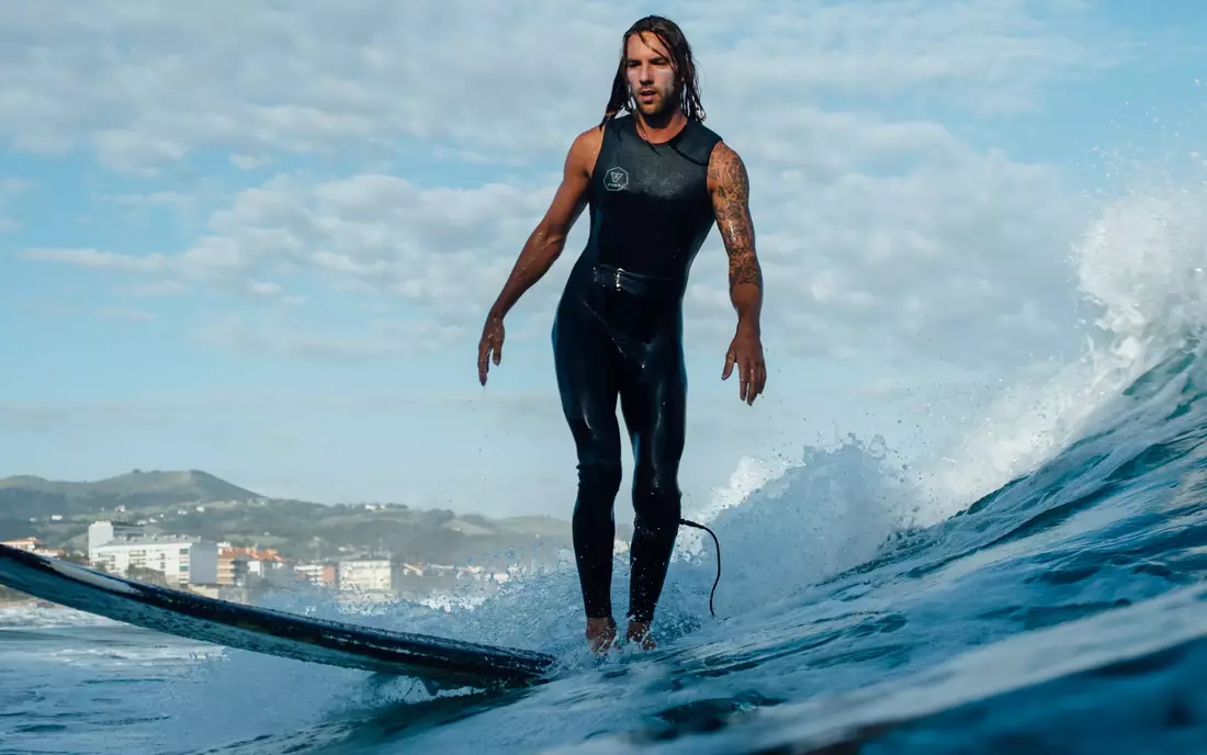 Surfboard and wetsuit rental surfer on a surfboard in the ocean