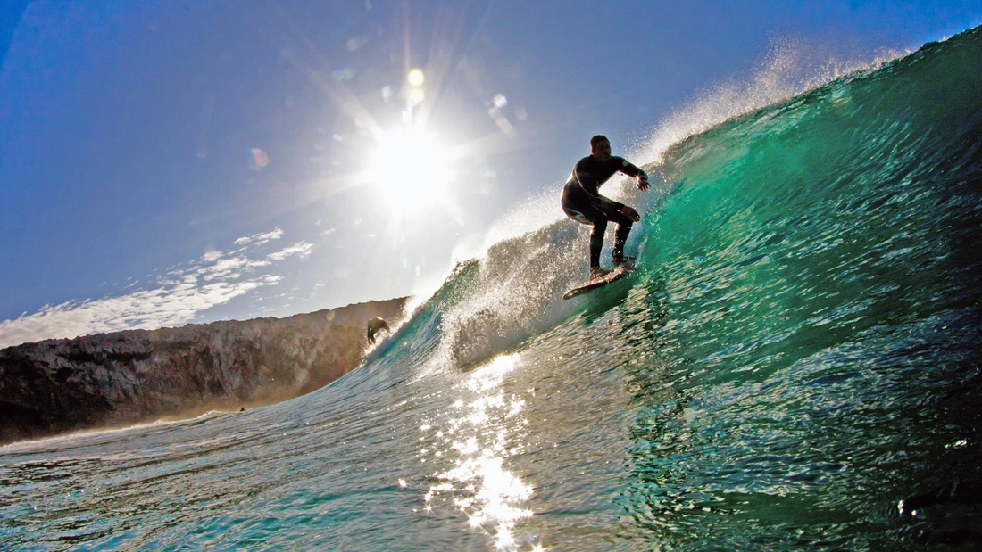 Surfer auf einer grünen Welle