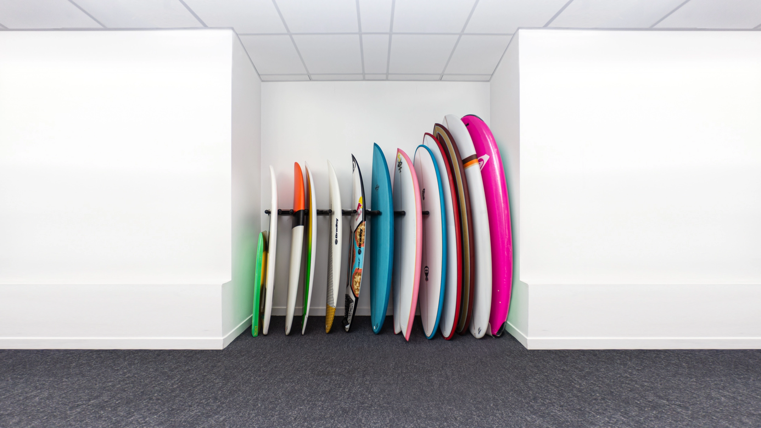 Surfbretter in verschiedenen Shapes und Farben an einer Wand