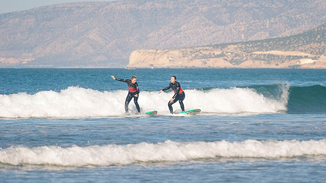 Surfanfängerinnen beim Weißwasser surfen