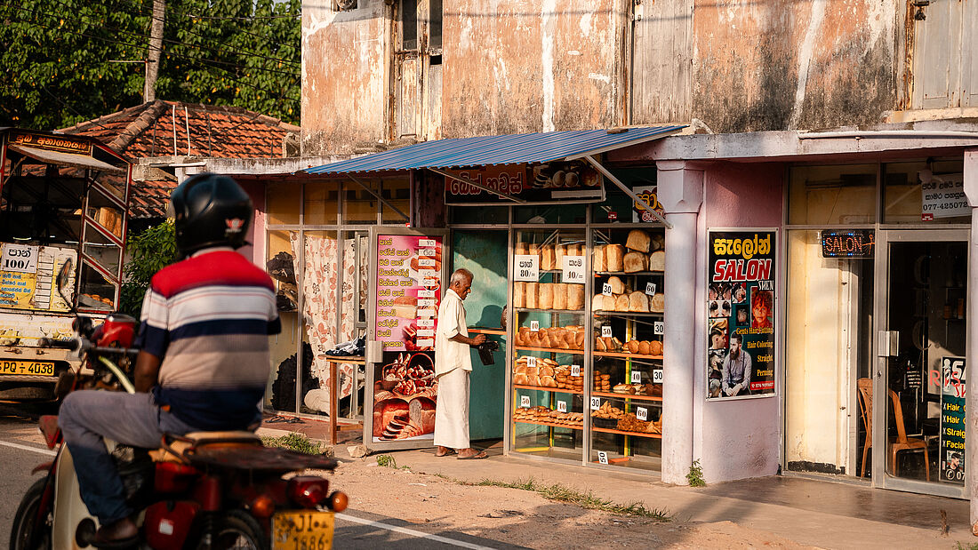 Rollerfahrer und Laden in Sri Lanka