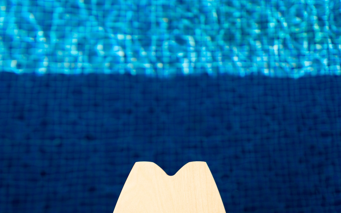 Das Balance Board Training lässt sich ideal in den Alltag integrieren Ende eines Balance Boards ragt in einen Pool