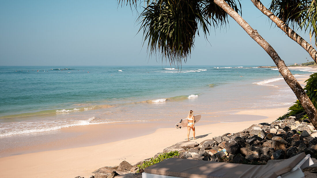 Surferin Am strand unter Palmen
