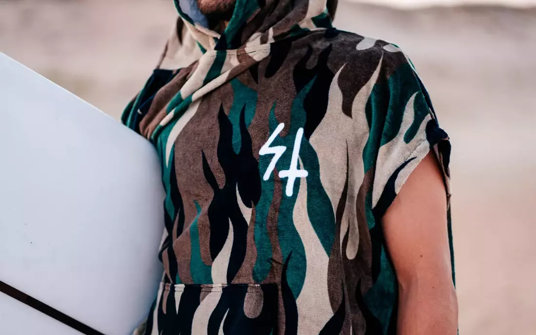 DIY Surf Poncho mit alten Frottee-Handtüchern und etwas Geschick an der Nähmaschine mann in gemustertem surfponcho mit kurzen aermeln von nah