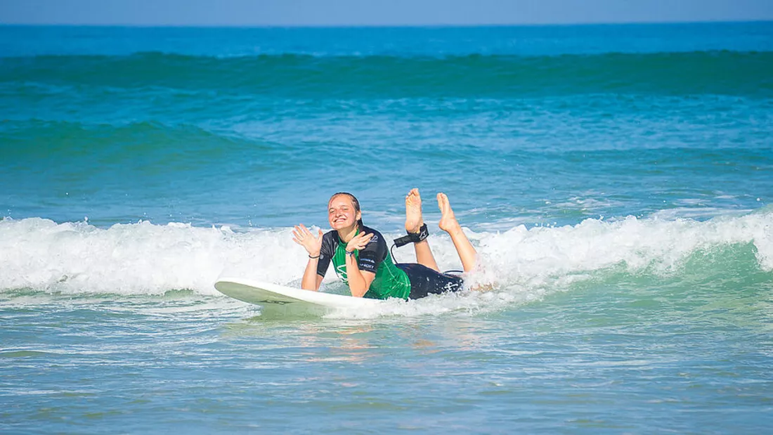 Surfschuelerin beim Surfen lernen im Weisswasser