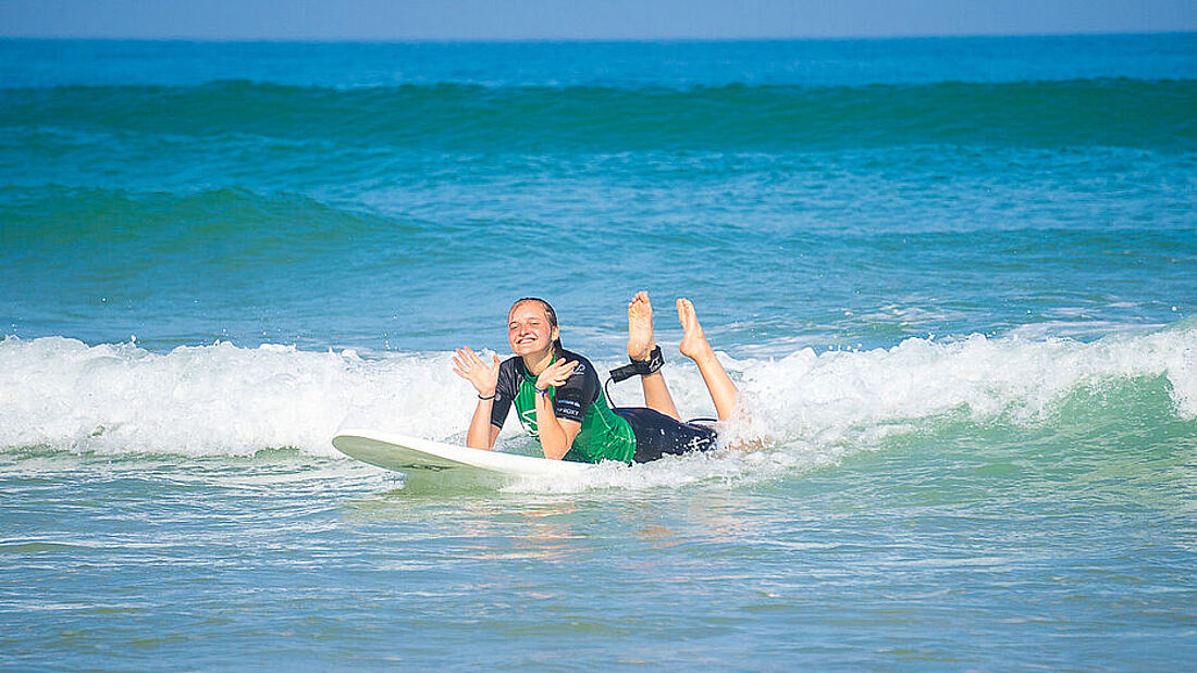 Surfschuelerin beim Surfen lernen im Weisswasser