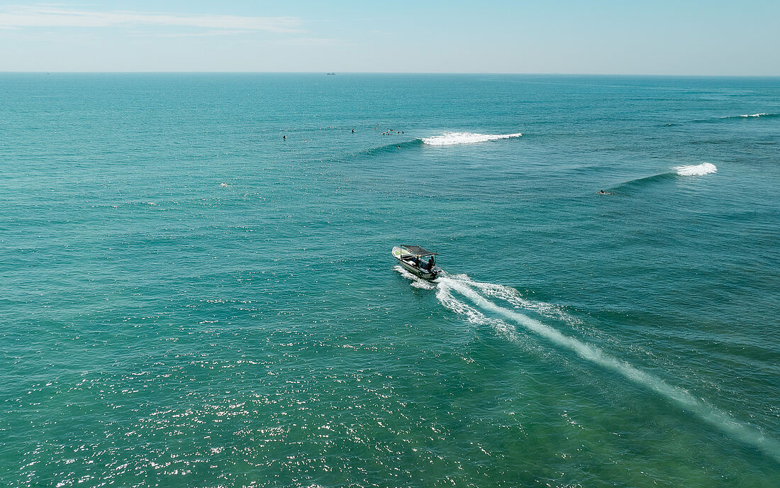 Speedboot und Wellen mit Surfern