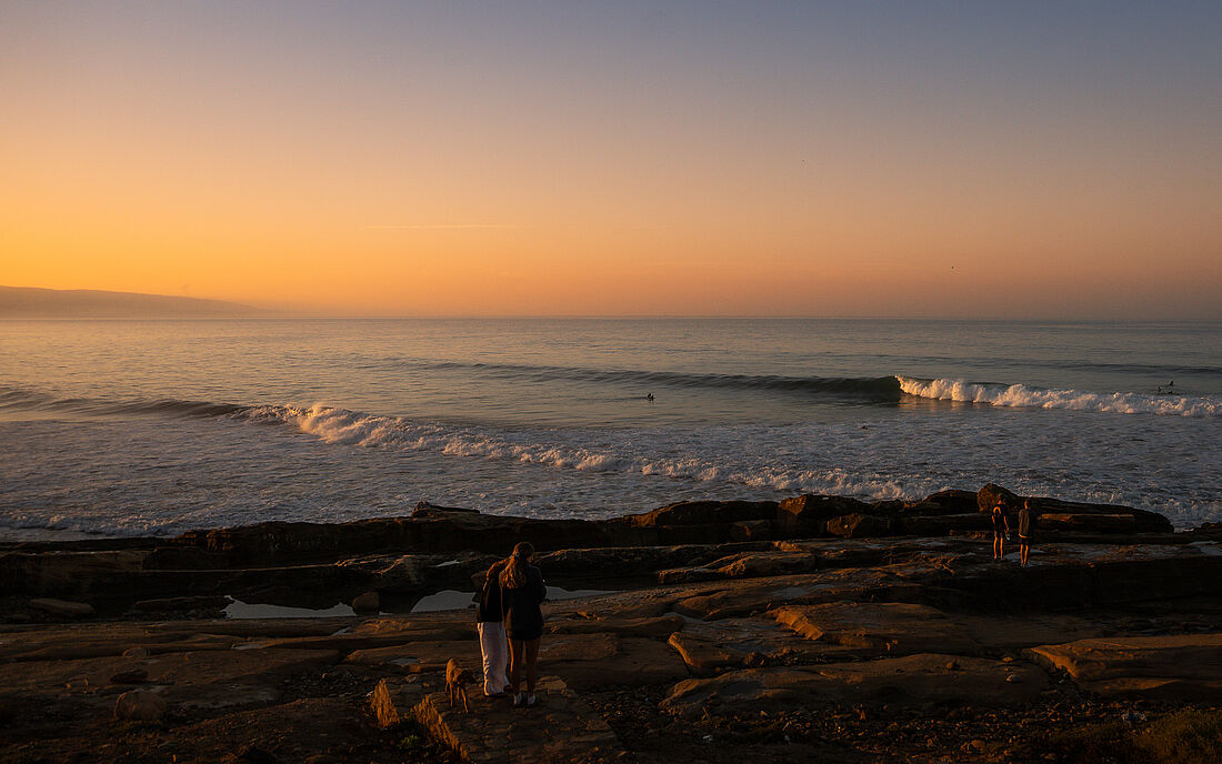 The surf continues even as the light fades.